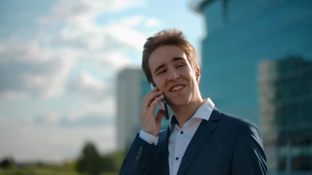 Cheerful smiling businessman answering a mobile phone call. Happy, friendly talk - Materiał filmowy, wideo