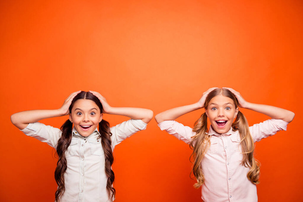 Wow autumn bargains. Portrait of funky crazy two kids hear incredible news scream omg touch hands head wear white shirts outfit isolated over orange color background - Foto, Bild