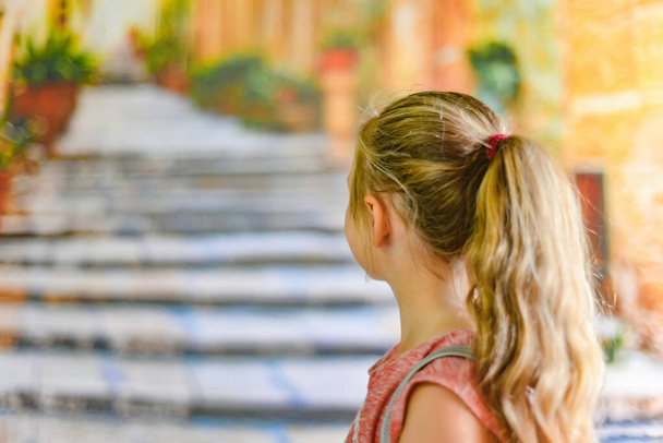 Una ragazza guarda i gradini della città vecchia, vista posteriore
. - Foto, immagini