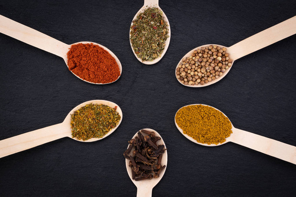 Colourful various herbs and spices on dark background. Top view - 写真・画像