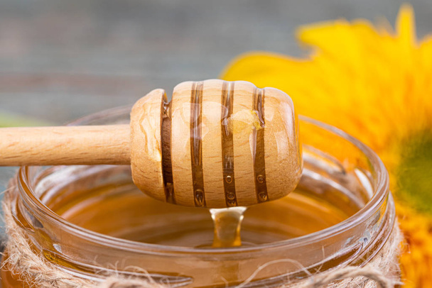 Fondo de miel. Miel fresca en maceta con girasol
 - Foto, Imagen
