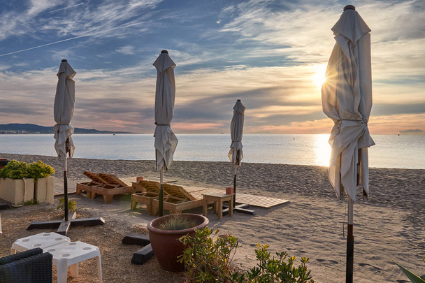 пляжный лосьон на восходе солнца с зонтиком
 - Фото, изображение