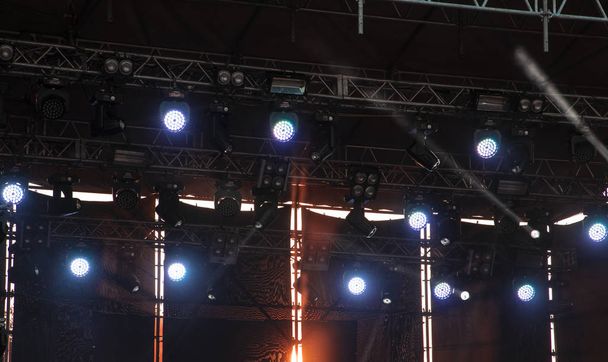 muziek podium buiten atmosferische sfeer projector verlichting met dramatische zonsondergang oranje licht achter de bouw  - Foto, afbeelding
