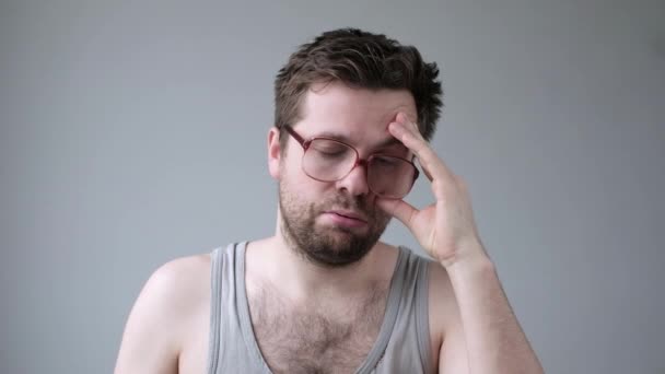 Jonge vermoeide man in grote glazen onder stress met problemen met slapeloosheid - Video