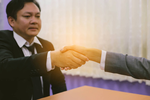 image of businessmen is shaking hands, businessman agrees to be the same cooperate in order to step through away the bad economy together. - Photo, Image