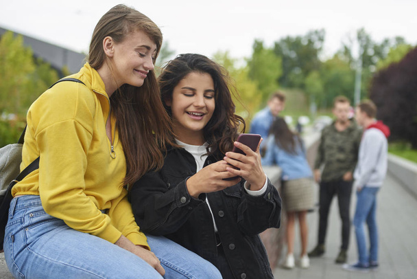 Счастливые девушки смотрят на смартфон
  - Фото, изображение
