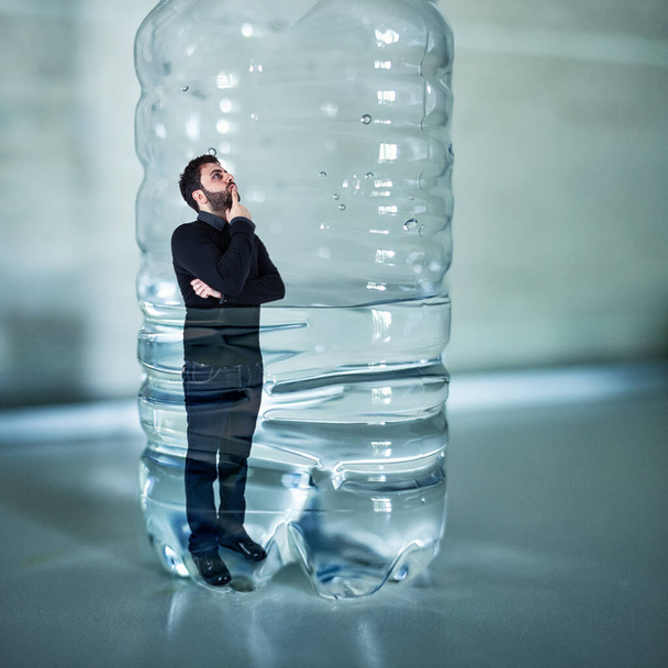 Mann in Plastikflasche eingeklemmt Kunststofffreies Konzept. - Foto, Bild