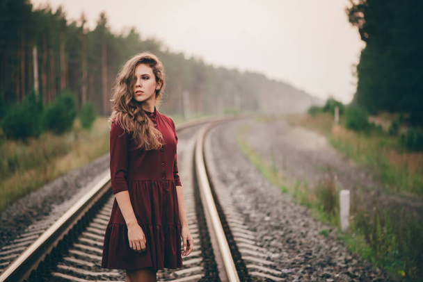 Όμορφο κορίτσι με σγουρά φυσικά μαλλιά απολαμβάνουν τη φύση στο δάσος στο σιδηρόδρομο - Φωτογραφία, εικόνα