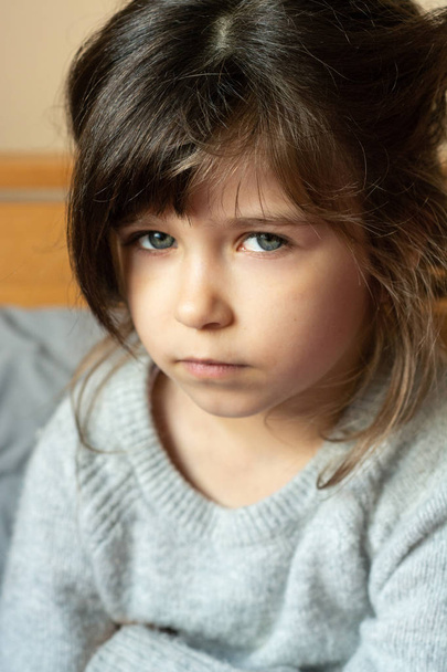 Little child with puzzled look.  Small child  with curly brown-haired, big blue eyes 6 or 5 years old. Whats wrong. - Photo, Image