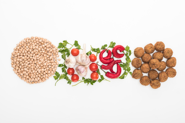 top view of chickpea, garlic, cherry tomatoes, parsley, chili pepper and falafel on white background - Foto, imagen