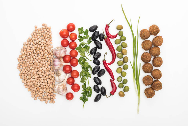 top view of chickpea, garlic, cherry tomatoes, parsley, olives, chili pepper, green onion and falafel on white background - Photo, Image