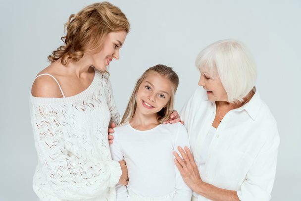 smiling mother, grandmother and granddaughter hugging isolated on grey  - Photo, Image