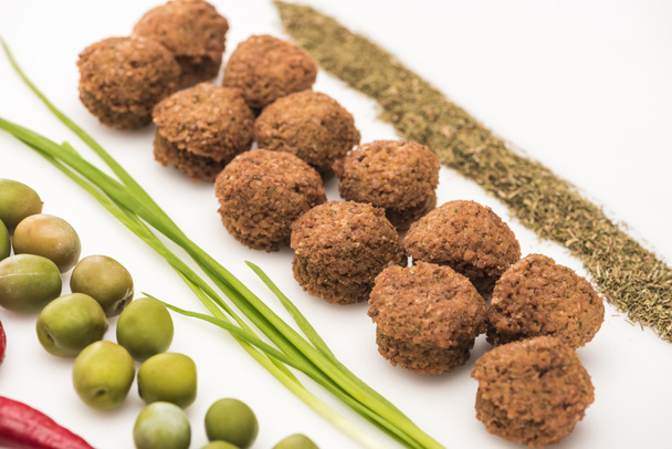 close up view of olives, green onion, herb and falafel on white background - Foto, Bild