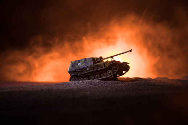 Válečný koncept. Vojenské siluety bojující s scénou na pozadí válečné mlhy, siluetu obrněného vozu pod mračnou Skyline v noci. Útočná scéna. Bitva o tanky. - Fotografie, Obrázek