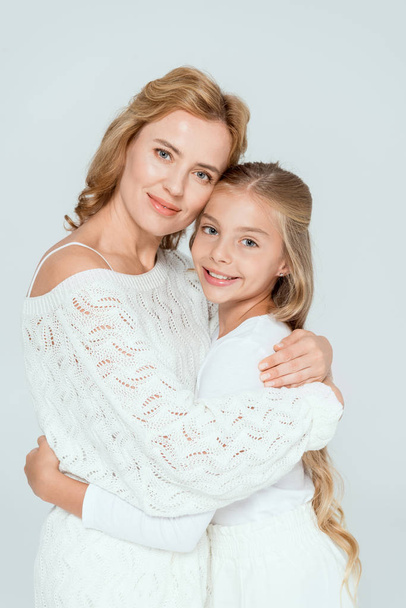 attractive mother hugging smiling daughter and looking at camera isolated on grey  - Valokuva, kuva