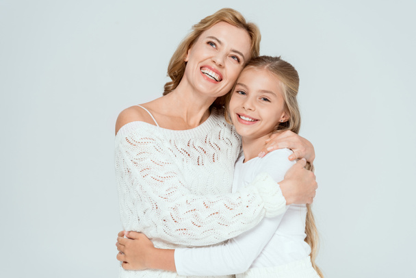 attractive mother hugging smiling daughter and looking up isolated on grey  - Foto, Imagen