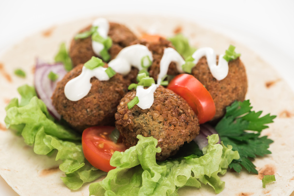 close up view of fresh falafel balls on pita with vegetables and sauce on white background - Φωτογραφία, εικόνα