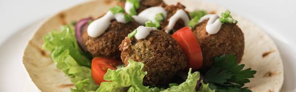 close up view of falafel with sauce on pita with vegetables in white plate, panoramic shot - Photo, Image