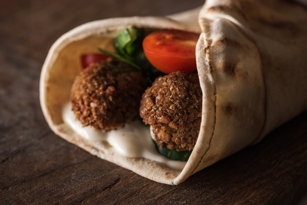 close up view of falafel with sauce and vegetables in pita - 写真・画像