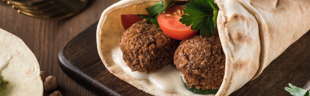 close up view of falafel with vegetables and sauce on pita on wooden table, panoramic shot - Φωτογραφία, εικόνα