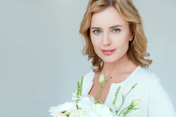 attractive woman with bouquet looking at camera isolated on grey - Fotoğraf, Görsel