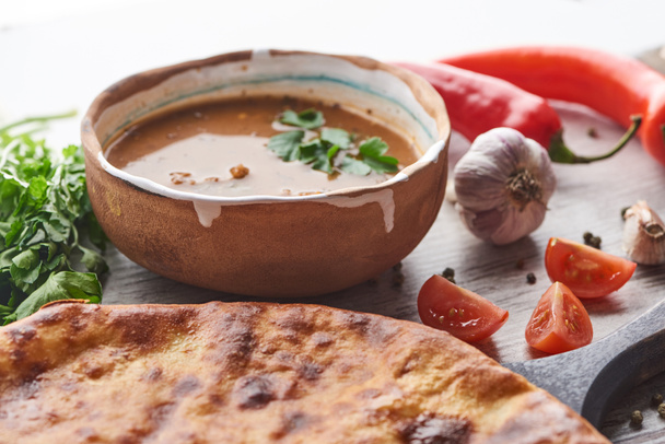 imereti khachapuri und Suppe kharcho mit Koriander und Gemüse auf dem Tisch - Foto, Bild