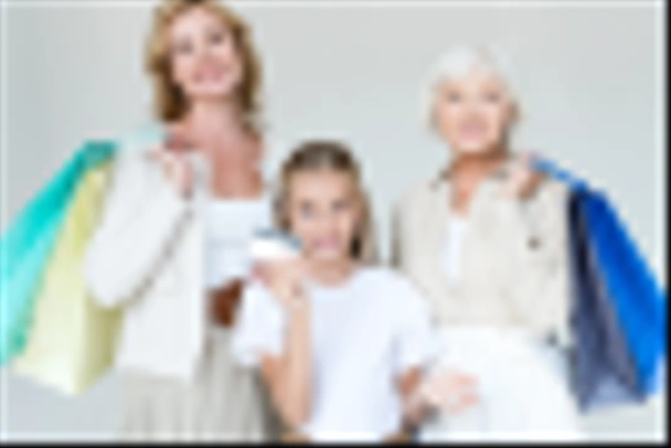 smiling granddaughter holding credit card, grandmother and mother with shopping bags isolated on grey  - Foto, Bild