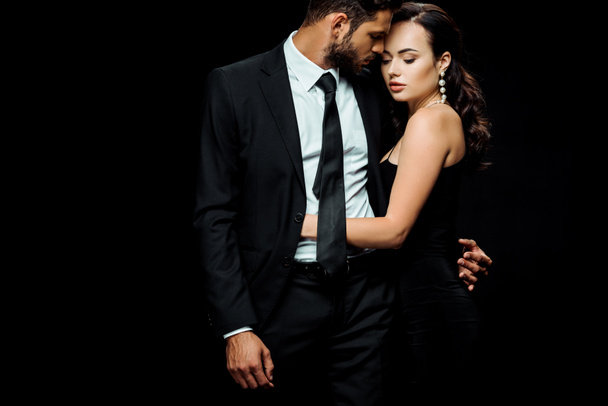 attraente donna in abito abbraccio bello uomo isolato su nero
  - Foto, immagini