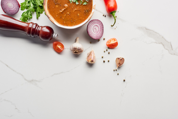 Bovenaanzicht van soep kharcho met koriander en groenten op marmeren textuur - Foto, afbeelding
