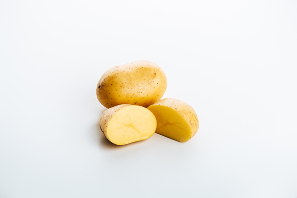 сырой цельный и сократить свежий картофель на белом фоне
 - Фото, изображение