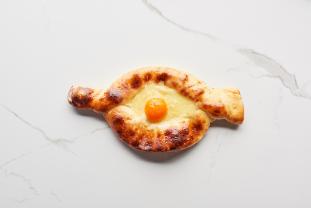 Top view of traditional adjarian khachapuri on marble texture - Photo, Image