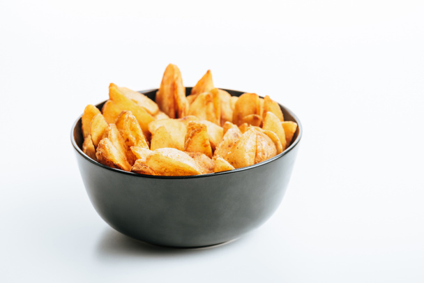 köstliche goldene Kartoffelkeile in Schüssel auf weißem Hintergrund - Foto, Bild