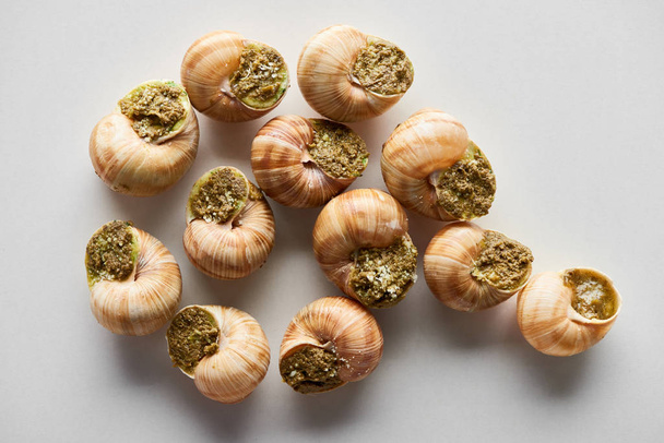 top view of delicious cooked escargots on white background - Foto, Bild