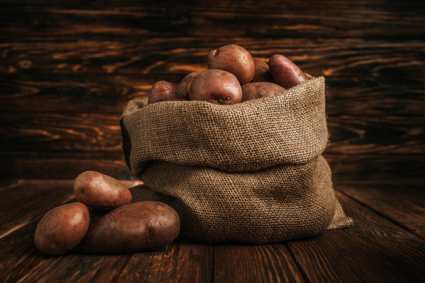 pommes de terre mûres dans un sac rustique sur fond de bois
 - Photo, image