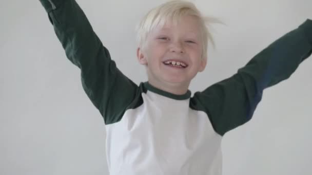 glücklicher Junge springt auf und hebt die Hände - Filmmaterial, Video