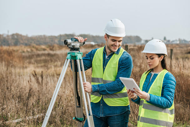 Surveyors working with digital level and tablet in field - Photo, Image