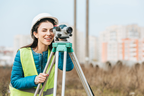 Smiling Surveyor looking through digital level - Фото, зображення