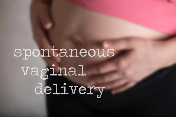 Words SPONTANEOUS VAGINAL DELIVERY. Young pregnant between 30 an - Photo, Image