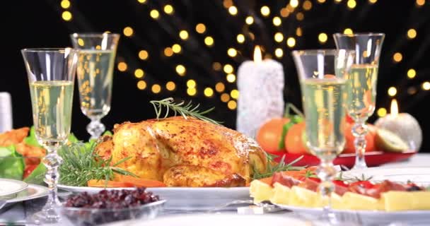 Roasted chicken ready to be served on Christmas festive table with champagne near Christmas tree and candles. Dolly shot 4k - Footage, Video