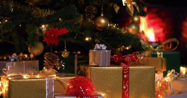 Presentes de Natal perto da árvore de Natal em luzes atmosféricas na frente da lareira. Dolly atirou 4k
 - Filmagem, Vídeo