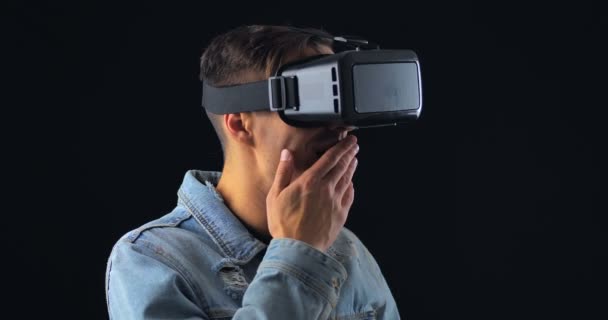 Nuoren miehen muotokuva käyttäen VR-laseja mustalla taustalla. Mies Virtual Reality Console Kuulokkeet Pelaa 3D Gaming Innovation Internet Entertainment Technology
 - Materiaali, video