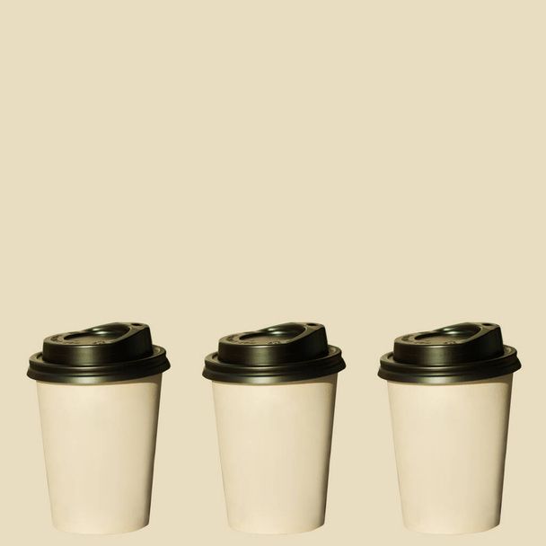 ホットコーヒーと紙カップは、ベージュのパステルの背景に隔離されます。飲み物、ファーストフードを取りなさい。コピースペース,価格タグ. - 写真・画像