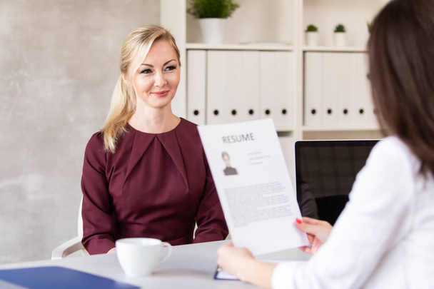 Employer examine resume and talks with candidate for job in her company - Foto, Bild