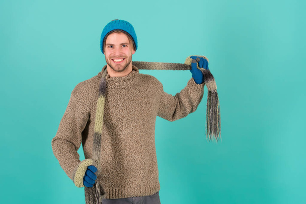Feeling good. Man smiling handsome unshaven guy wear winter accessories on blue background. Shopping concept. Emotional expression. Winter season sale. Hipster knitted winter hat scarf and gloves - Фото, зображення