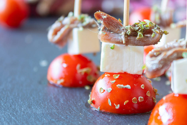 Нарезка помидоров черри с анчоусами и свежим сыром
 - Фото, изображение