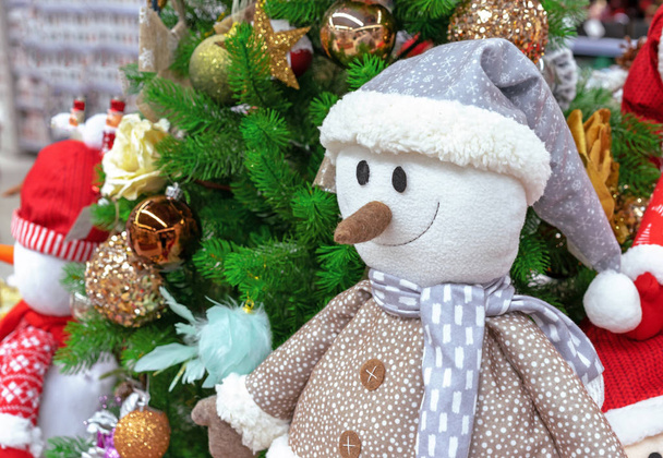 Joulun pehmeä lelu lumiukko pukeutunut takki, huivi ja hattu
. - Valokuva, kuva
