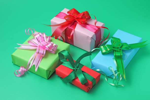 Gifts in colored packaging on a green background, the concept of a festive congratulation. - 写真・画像