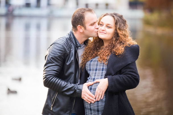 Feliz pareja embarazada en el fondo de otoño
 - Foto, Imagen