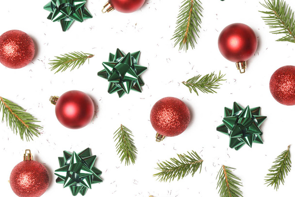 クリスマスの装飾赤いクリスマスの光沢のあるボールと白い背景に隔離されたモミの小枝。クリスマスオーナメントのアレンジ. - 写真・画像