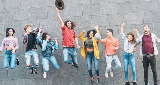Grupa młodych ludzi skaczących razem na świeżym powietrzu - Szczęśliwych milenijnych przyjaciół świętujących sukces w koledżu - Koncepcja stylu życia i przyjaźni młodzieży - Zdjęcie, obraz
